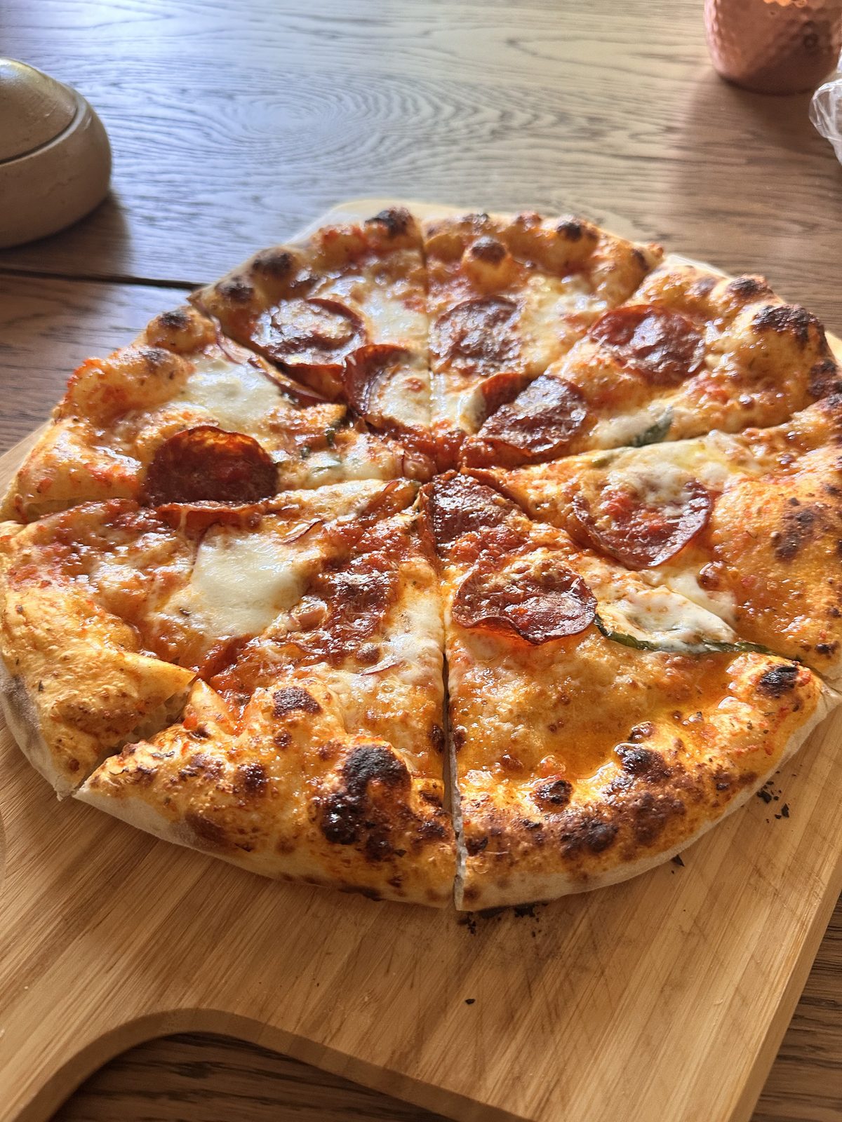 New York style pizza with a raised, bubbled rim, shot from an angle to show the height of the crust